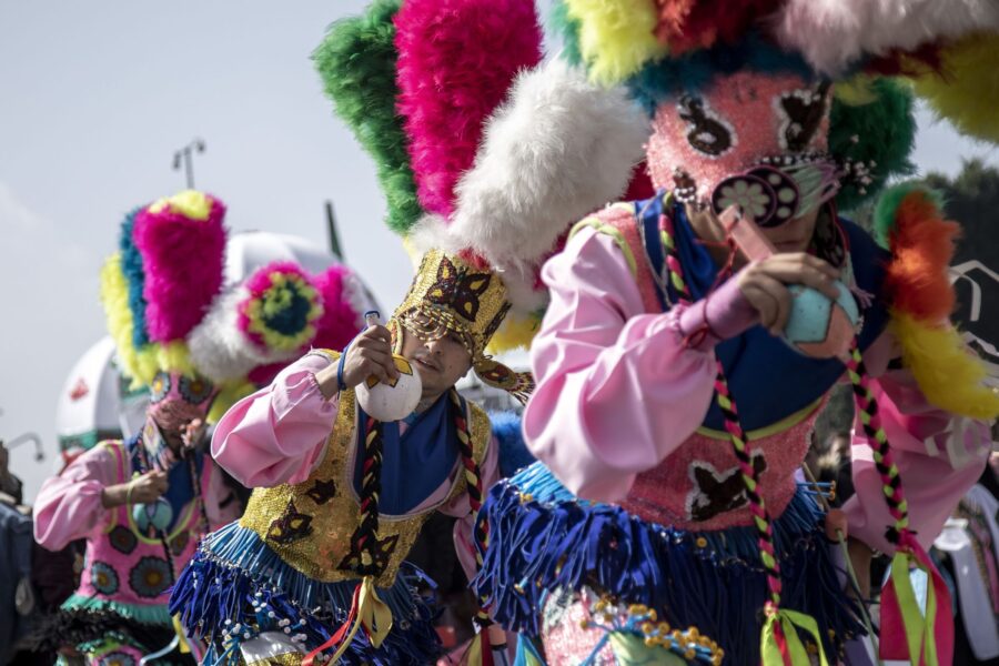 Danzantes con máscaras y penachos de plumas de colores
