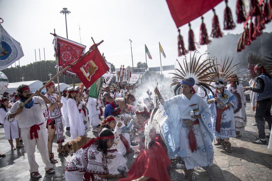 Peregrinos y danzantes con estandartes entre el humo del copal