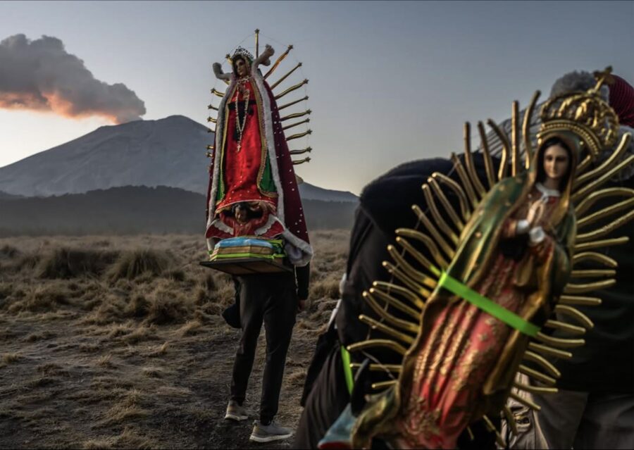 Peregrinos cargan imágenes de la Virgen de Guadalupe en el Paso de Cortés, con el Popocatépetl al fondo
